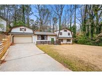 Charming home featuring a unique architectural style, complemented by a spacious front yard and mature trees at 3457 Scenic Dr, East Point, GA 30344