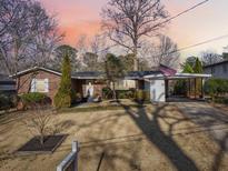 Charming single-story brick home with an attached carport, manicured lawn, and mature trees at 3831 Montford Dr, Atlanta, GA 30341