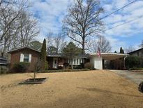 Charming brick home featuring a large front yard and covered carport at 3831 Montford Dr, Atlanta, GA 30341