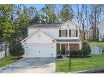 Charming two-story home featuring a white exterior, attached garage, manicured lawn, and mature trees at 455 Registry Blf, Stone Mountain, GA 30087
