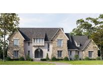 Stunning stone-and-shingle home featuring a arched entry, complemented by lush landscaping and a serene pathway at 133 Laurel Brook Ln, Canton, GA 30115
