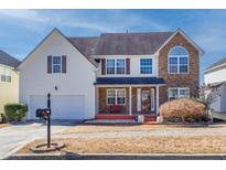 Charming two-story home with a combination of vinyl siding and brick facade with front porch at 4381 Prather Son Dr, Loganville, GA 30052