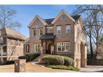 Stately two-story brick home with manicured landscaping and charming architectural details at 1207 Thornwell Ne Dr, Brookhaven, GA 30319