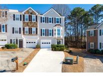 Charming townhome with a one car garage, featuring a landscaped front yard and neutral colored siding at 2021 Pinnacle Pointe Dr, Norcross, GA 30071