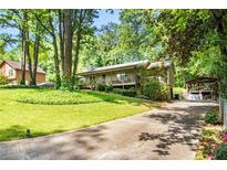 Charming home boasts a well-manicured lawn and a cozy carport, surrounded by mature trees at 4352 Treeline Way, Douglasville, GA 30135