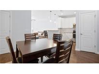 Open-concept dining area featuring dark wood table and chair set next to the bright kitchen and cozy living room at 10 Perimeter Summit Ne Blvd # 4243, Atlanta, GA 30319