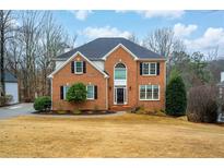 Charming two-story brick home featuring a well-manicured lawn and classic architectural details at 2330 Ivey Oaks Rd, Cumming, GA 30041