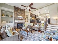 Bright living room featuring a stone fireplace, built-in shelving, and comfortable seating with a ceiling fan at 255 Southerland Ne Ter # 207, Atlanta, GA 30307