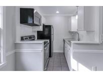 Cozy kitchen featuring white cabinets, stainless steel appliances, and tile backsplash at 86 De Arc Nw Pl, Atlanta, GA 30327
