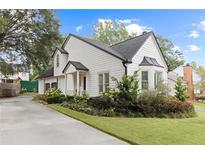 Charming, newly renovated two-story home showcasing landscaped yard and light-colored siding with a dark roof at 1054 Club Ne Pl, Atlanta, GA 30319