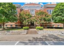 Brick building exterior featuring beautiful landscaping, including trees with pink flowers, and a classic stone facade at 978 North Ne Ave # 307, Atlanta, GA 30306