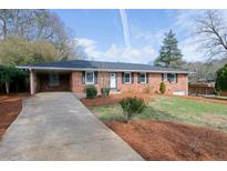 Charming single-story brick home with a long driveway and well-maintained front yard at 636 Counsel Ne Dr, Marietta, GA 30068