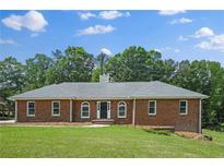 Charming brick home with a well-manicured lawn, beautiful trees, and a classic design at 9035 Teal Ln, Jonesboro, GA 30236