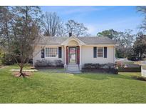 Charming single-story home with a well-manicured lawn and inviting front entrance at 1040 Manor Se Dr, Smyrna, GA 30080