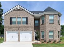 Two-story brick home with a two-car garage and manicured lawn at 637 Egrets Landing #51, Covington, GA 30014