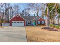 Charming single Gathering home features brick accents, attached two car garage, mature trees and landscaping at 5883 Riverside Walk Dr, Sugar Hill, GA 30518