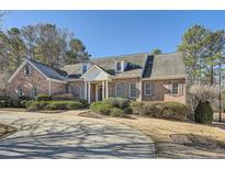 A beautiful brick home with a manicured lawn and a circular driveway at 1725 Patriots Nw Way, Kennesaw, GA 30152