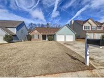 Charming single-story home featuring a two-car garage, manicured lawn and inviting curb appeal at 530 Firethorn Ct, Villa Rica, GA 30180