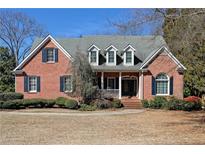 Charming two-story brick home featuring classic architectural details and manicured landscaping at 3894 Stone Lake Nw Dr, Kennesaw, GA 30152