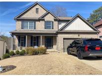 Charming brick two-story home featuring a welcoming front porch, dark shutters, and a well-maintained lawn at 526 Blue Mountain Rise, Canton, GA 30114