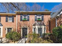 Charming brick townhome featuring black shutters and manicured landscaping at 1281 Whitlock Ridge Sw Dr, Marietta, GA 30064