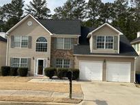 Charming two-story home featuring a two-car garage and neutral-colored siding at 6497 Snowden Dr, South Fulton, GA 30349