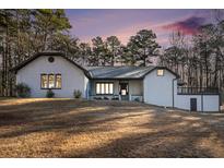 Charming single-story home with a textured facade, complemented by mature trees and a spacious front yard at 1675 Dodson Sw Dr, Atlanta, GA 30311