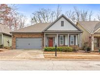 Charming single-Gathering home with a two-car garage, brick accents, a red front door, and manicured landscaping at 250 High Court Way, Locust Grove, GA 30248