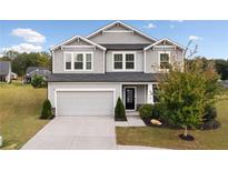 Charming two-story home with gray siding, manicured lawn and a two-car garage at 500 Appalachian Pl, Canton, GA 30114
