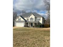 Inviting two-story home features a well-manicured lawn and attached two-car garage at 215 Bradley St, Covington, GA 30016