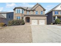 Charming two-story brick home with well-manicured lawn and attached two-car garage at 615 Ceremony Way, Acworth, GA 30102