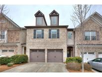 Charming brick townhome featuring a two-car garage and inviting curb appeal with a well-manicured lawn at 2069 Brightleaf Way # 123, Marietta, GA 30060