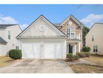 Charming two-story home featuring a two-car garage and a stone facade accent, set against a bright blue sky at 3226 Wellington Sw Walk, Atlanta, GA 30331