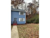 Charming two-story home with blue siding and white shutters on a tree-lined street at 6950 Oakhill Se Cir, Austell, GA 30168