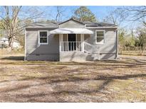 Charming single-story home with gray siding, covered porch, and well-maintained front yard at 1412 Evans Dr, Riverdale, GA 30296