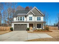 Charming two-story home with neutral siding, gray accents, covered porch, and a two car garage at 3560 Pleasant Grove Rd, Cumming, GA 30028