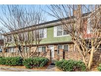 Charming two-story townhouse featuring a brick facade, landscaped front yard, and inviting entrance at 307 Adair St # 7-E, Decatur, GA 30030