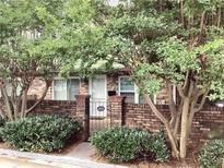 Charming brick townhouse featuring a quaint gate and lush greenery enhancing curb appeal at 307 Adair St # 7-E, Decatur, GA 30030