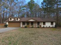 Charming single-story home featuring a well-manicured front lawn and an attached two car garage at 6832 Shangrila Way, Riverdale, GA 30296