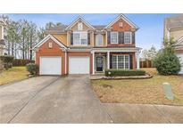 Charming two-story home with brick and siding, featuring a well-manicured lawn and a two-car garage at 1641 Hedington Ct, Lawrenceville, GA 30045