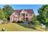Beautiful brick two-story home with mature trees and a well-manicured front yard at 1755 Riverpark Dr, Dacula, GA 30019