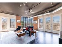 Bright living room featuring a large window, exposed brick wall, and open layout with an industrial design at 395 Central Park Ne Pl # 420, Atlanta, GA 30312