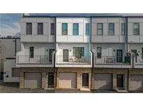 Modern townhome exterior features individual garages, steel railings, and small balconies for each unit at 2030 Main Nw St # 205, Atlanta, GA 30318