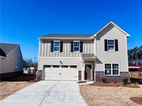 Charming two-story home with a brick-accented foundation and a well-manicured front yard at 7714 Sudbury Cir, Covington, GA 30014