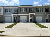 Charming townhouse featuring a one car garage and inviting entrance at 8656 Webb Rd, Riverdale, GA 30274