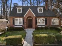 Charming brick home featuring dormer windows, mature landscaping, and a welcoming walkway at 787 Martina Ne Dr, Atlanta, GA 30305