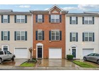 Charming townhome with a brick facade, complemented by a one-car garage and well-manicured landscaping at 5392 Fox Creek Ln, Norcross, GA 30071