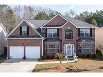 Stunning brick home with manicured lawn, two-car garage and striking architectural details at 1893 Tulip Petal Rd, Auburn, GA 30011