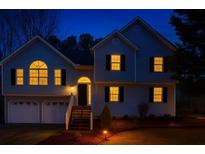 Charming two-story home with warm interior lights shining from the windows at night at 13 Greystone Nw Ln, Cartersville, GA 30121