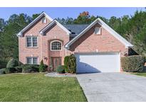 Charming two-story brick home featuring a well-manicured front yard and attached two-car garage at 1012 Blankets Creek (15N08E-00000-004-000) Dr, Canton, GA 30114